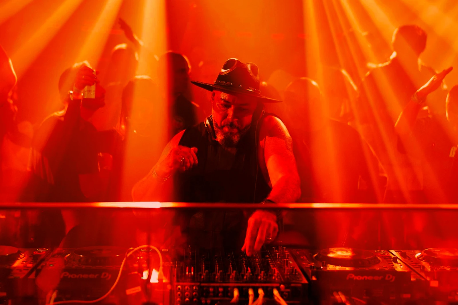 Roger Sanchez mezclando en la cabina, con sombrero y los haces de luz sobre el público